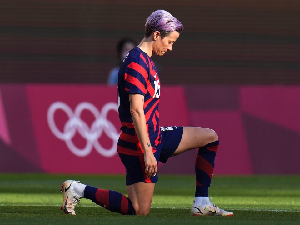 Megan Rapinoe kneels before kickoff.