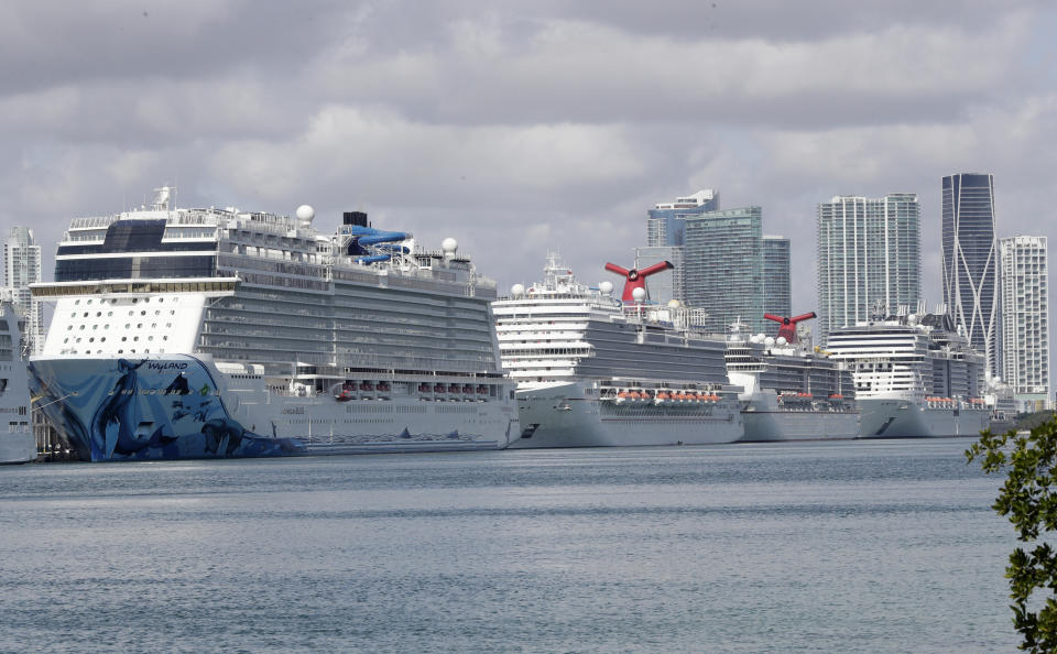 Cruise ships are docked at PortMiami, Tuesday, March 31, 2020, in Miami. The U.S. Coast Guard said Tuesday that it's working with Holland America on a detailed docking plan that would require two ships carrying passengers and crew from an ill-fated cruise to handle all medical issues without impacting South Florida's already-stressed hospitals. (AP Photo/Wilfredo Lee)