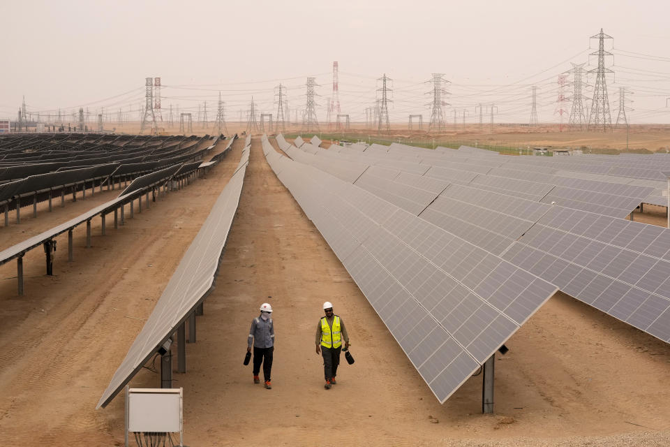 Engineers walk next to solar panels at Benban Solar Park, one of the world's largest solar power plant in the world, in Aswan, Egypt, Wednesday, Oct. 19, 2022. (AP Photo/Amr Nabil)