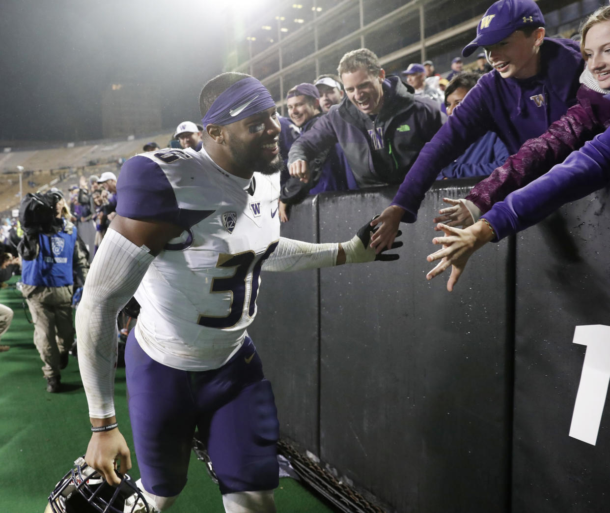 Washington linebacker Azeem Victor is congratulated by fans as he leaves the field after the team’s NCAA college football game against Colorado on Saturday, Sept. 23, 2017, in Boulder, Colo. Washington won 37-10. (AP Photo/David Zalubowski)