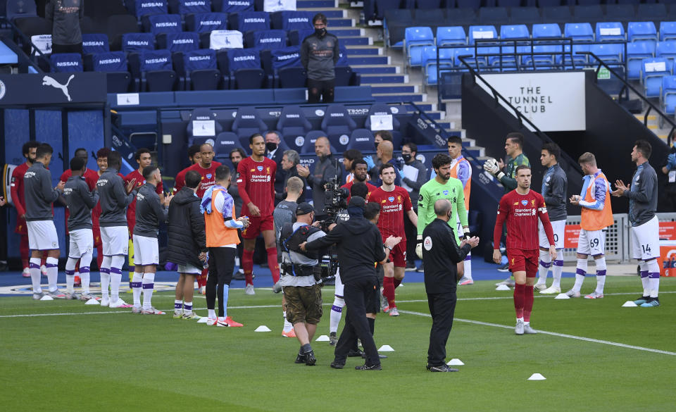 Los jugadores del Liverpool entran en el terreno mientras sus rivales del Manchester City les forman un pasillo, antes del partido del jueves 2 de julio de 2020, en la Liga Premier inglesa (AP Photo/Laurence Griffiths,Pool)