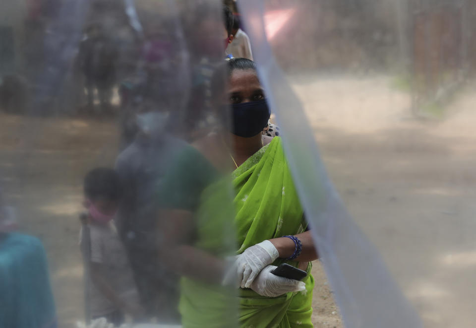 People wait in a queue to register their names before giving their nasal swab samples to test for COVID-19 in Hyderabad, India, Saturday, Aug. 22, 2020. India has the third-highest caseload after the United States and Brazil, and the fourth-highest death toll in the world. (AP Photo/Mahesh Kumar A.)