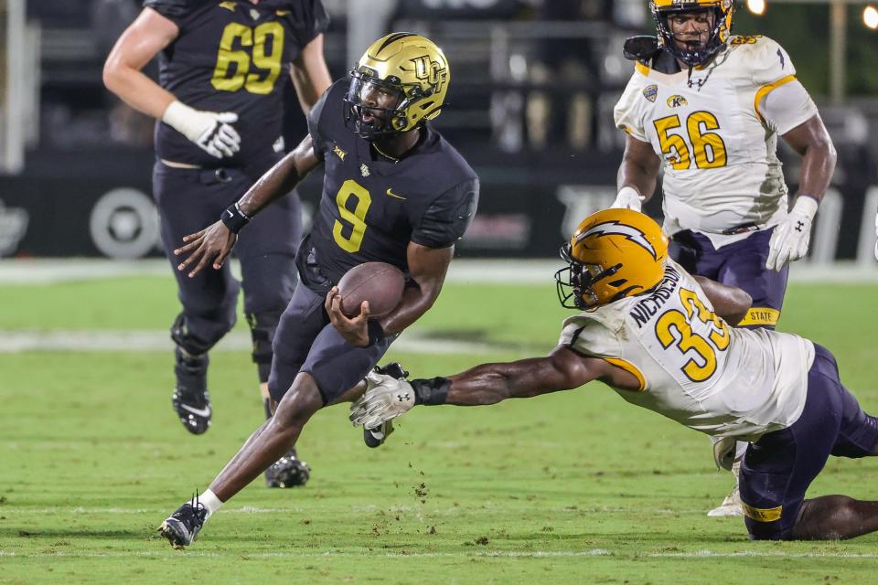Aug 31, 2023; Orlando, Florida, USA; UCF Knights quarterback Timmy McClain (9) runs the ball in front of Kent State Golden Flashes linebacker Devin Nicholson (33) during the second half at FBC Mortgage Stadium. Mandatory Credit: Mike Watters-USA TODAY