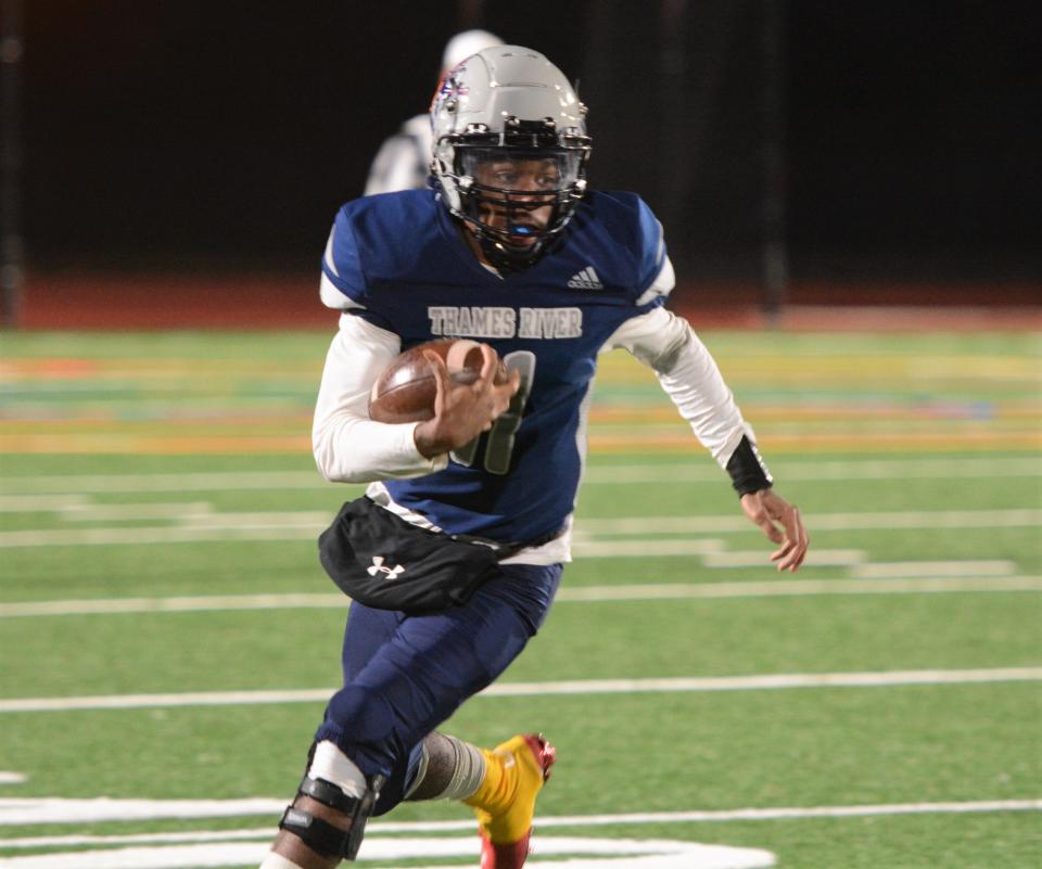 Thames River quarterback Justin Outlow eyes the end zone during a game last season at Grasso Tech.