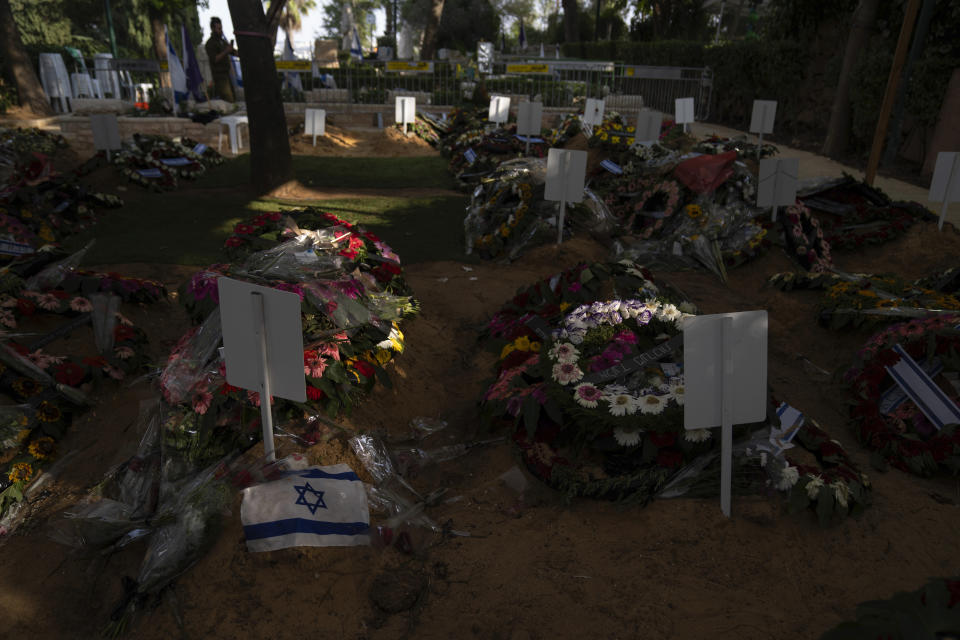 Una bandera israelí yace junto a flores sobre la tumba de un soldado muerto en la guerra entre Israel y Hamas, en el cementerio militar del Monte Herzl, el lunes 16 de octubre de 2023, en Jerusalén. (AP Foto/Petros Giannakouris)