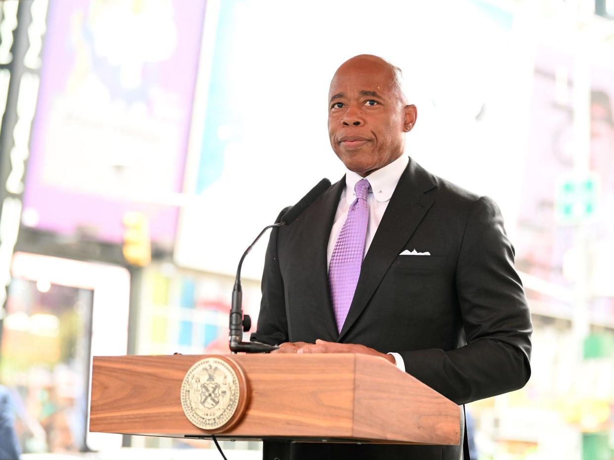 Eric Adams speaks at a podium in Times Square