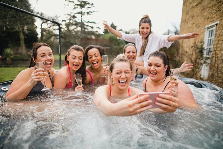 Women in Jacuzzi taking a photo.