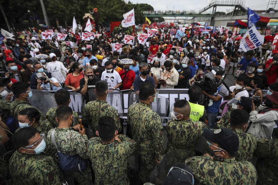Police block protesters as they try to march towards the House of Representative where Philippine President Rodrigo Duterte is set to deliver his final State of the Nation Address in Quezon city, Philippines on Monday, July 26, 2021. Duterte is winding down his six-year term amid a raging pandemic and a battered economy. (AP Photo/Gerard Carreon)