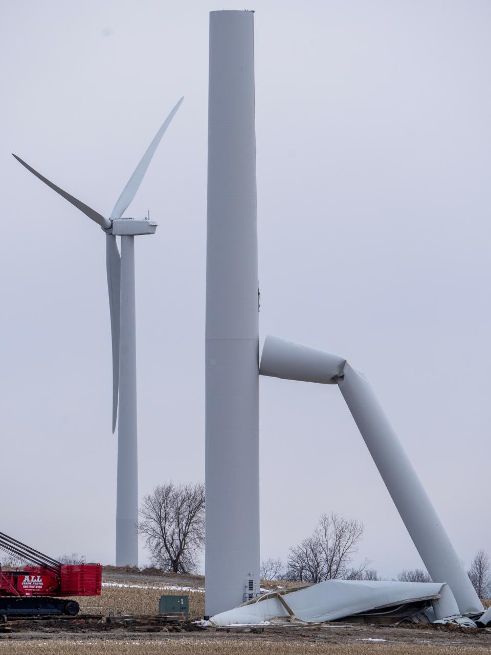 Workers stand around a crane near the wreckage of a wind turbine is shown Tuesday, February 21, 2023 in the Butler Ridge Wind farm in eastern Dodge County in Herman, Wis. Before its collapse in late January, the turbine stood about 400 feet above the ground, according to the National Weather Service. NextEra Energy Resources owns the turbine. The company said in statement that it believe that “this was an isolated incident as turbine malfunctions are rare." MARK HOFFMAN/MILWAUKEE JOURNAL SENTINEL