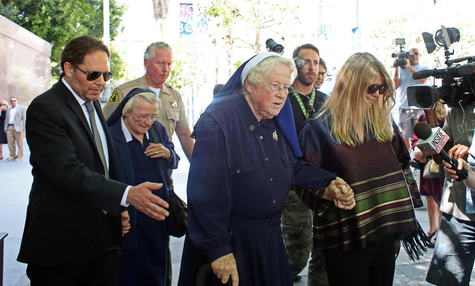 Sisters Catherine Rose Holzman, second left, and Rita Callanan, center, is escorted by businesswoman Dana Hollister, right, out of Los Angeles Superior Court on Thursday, July 30, 2015. The nuns are part of an order locked in a battle with Los Angeles' archbishop over the sale of their former convent, which pop singer Katy Perry wants to buy. A judge said Thursday that it appeared the nuns had improperly sold the property to Hollister, but warned the case will take months if not years to resolve. (AP Photo/Anthony McCartney)