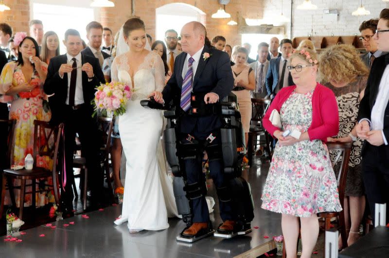 Un padre, que fue informado por los médicos en 2012 que no volvería a caminar de nuevo, tuvo la oportunidad de caminar junto a su hija hasta el altar el día de su boda con la ayuda de un traje biónico, en mayo de este año. Foto: Facebook.com/Rex-Bionics