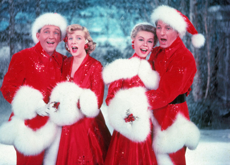 American actors Bing Crosby (1903 - 1977), Rosemary Clooney (1928 - 2002), Vera-Ellen (1921 - 1981), and Danny Kaye (1913 - 1987) sing together, while dressed in fur-trimmed red outfits and standing in front of a stage backrop, in a scene from the film 'White Christmas,' directed by Michael Curtiz, 1954