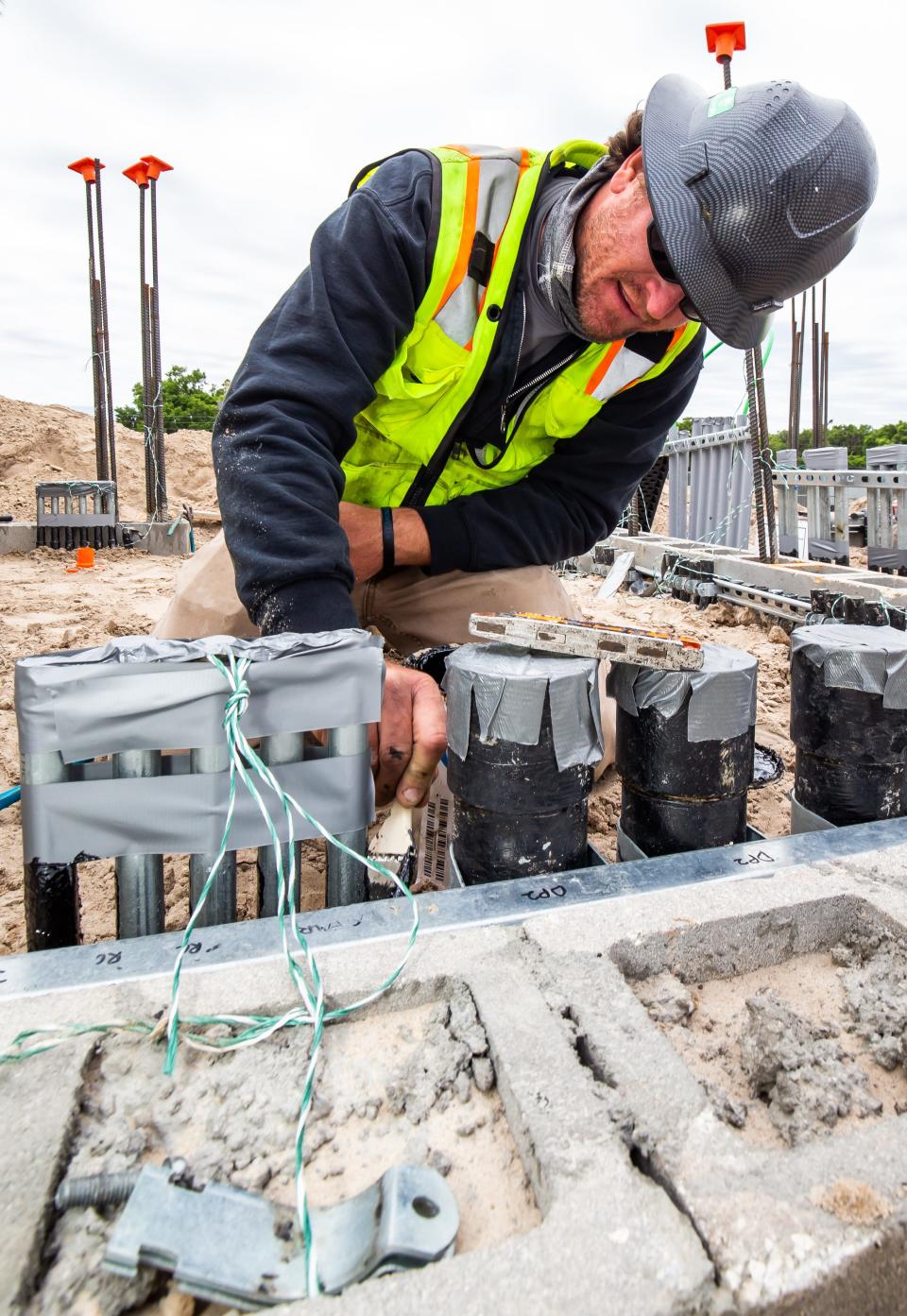 Casey Snyder with Electric Services Inc., water proofs the electrical conduit in one of the control rooms at the site of the new cafeteria at North Marion High School in 2021.