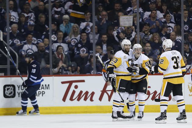 Winnipeg Jets’ Bryan Little (18) skates past as Pittsburgh Penguins’ Nick Bonino (13), Jake Guentzel (59) and Mark Streit (32) celebrate Bonino’s third goal of the night, during the second period of an NHL hockey game Wednesday, March 8, 2017, in Winnipeg, Manitoba. (John Woods/The Canadian Press via AP)