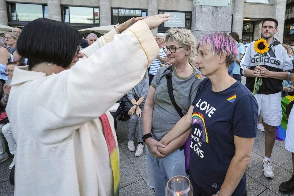 Same-sex couples take part in a public blessing ceremony in front of the Cologne Cathedral in Cologne, Germany, Wednesday, Sept. 20, 2023. Several Catholic priests held a ceremony blessing same-sex and also re-married couples outside Cologne Cathedral in a protest against the city's conservative archbishop, Cardinal Rainer Maria Woelki. (AP Photo/Martin Meissner)