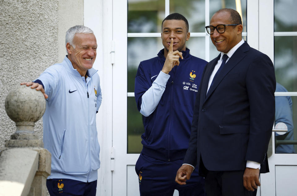 French soccer player Kylian Mbappe, center, gestures as he is flanked by head coach Didier Deschamps, left, and French Football Federation President Philippe Diallo, at the national soccer team training center in Clairefontaine, west of Paris, Monday, June 3, 2024 ahead of the UEFA Euro 2024. (Sarah Meyssonnier/Pool Photo via AP)