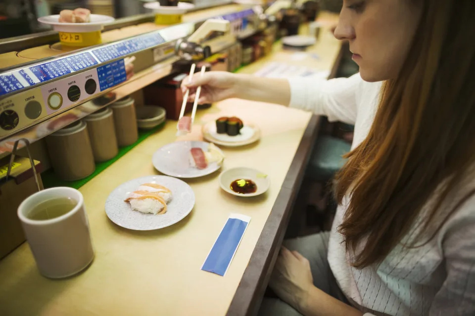 Mujer come en un restaurante Kaitenzushi. Foto: Getty Images