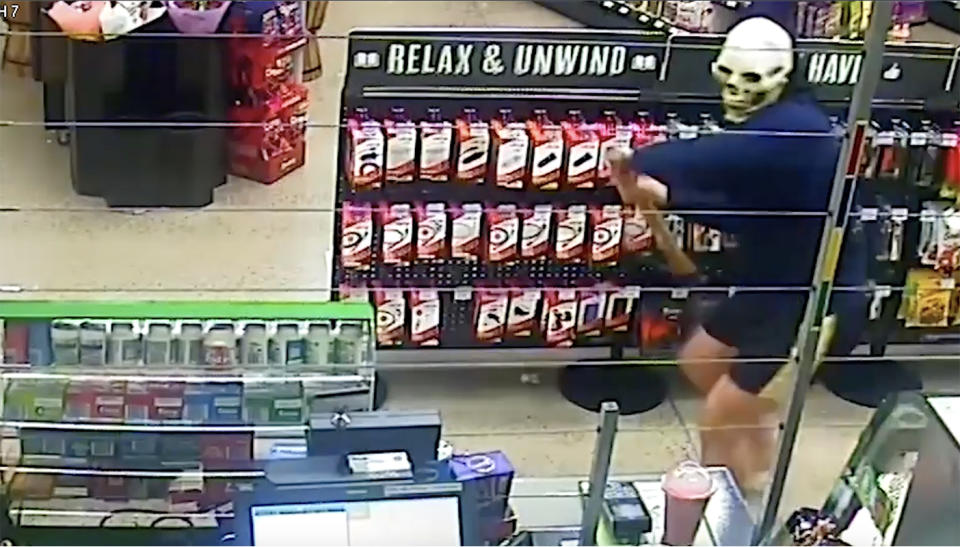 CCTV catches a masked man smashing up a Townsville service station with a mattock during an attempted armed robbery.