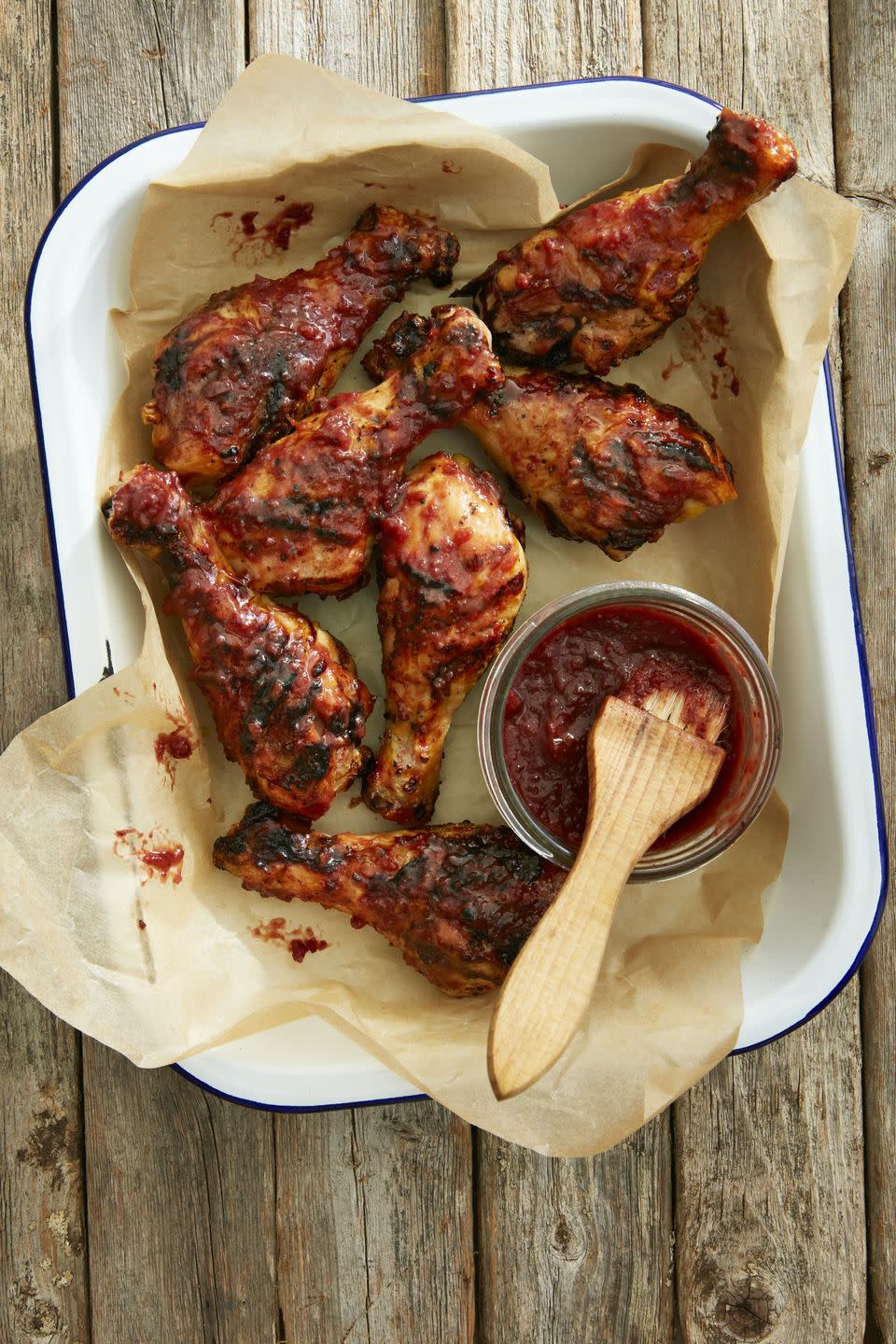 strawberry cabernet barbecue sauce on chicken legs in a rectangle serving dish