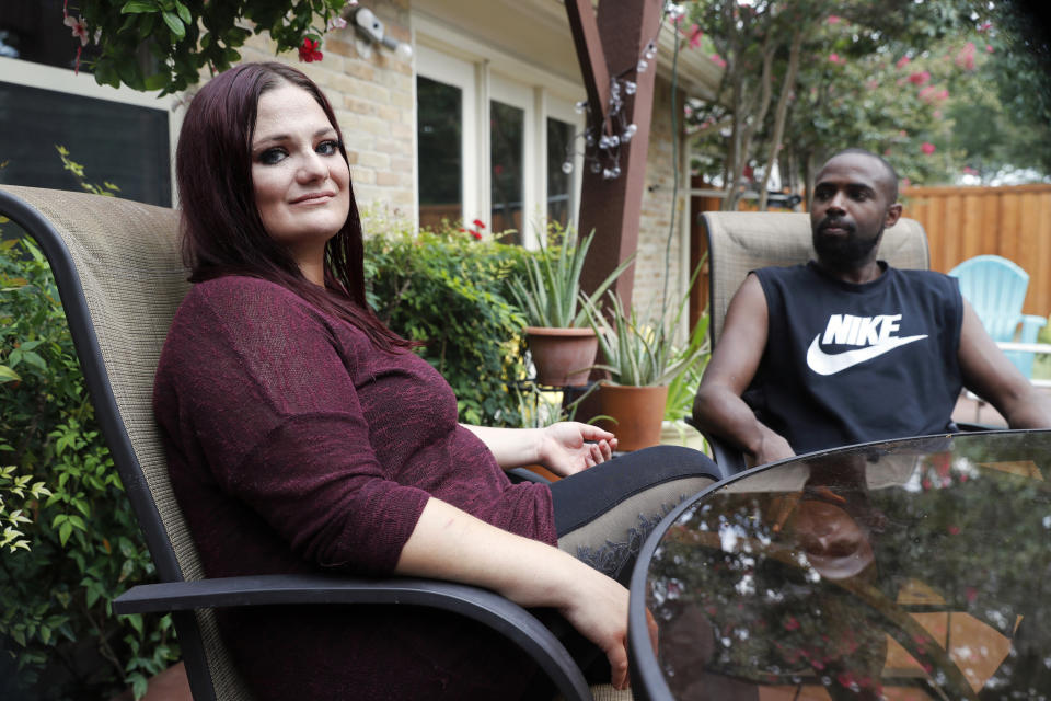 Bethany Racobs-Ashford poses for a photo with her husband, Chase, at her mother's home in Dallas, Wednesday, Aug. 5, 2020. Racobs-Ashford said that the extra $600 in federal benefits was a “lifeline" for her family. Racobs was just entering the busy wedding season, where she makes almost all her annual income, when the pandemic hit. (AP Photo/Tony Gutierrez)