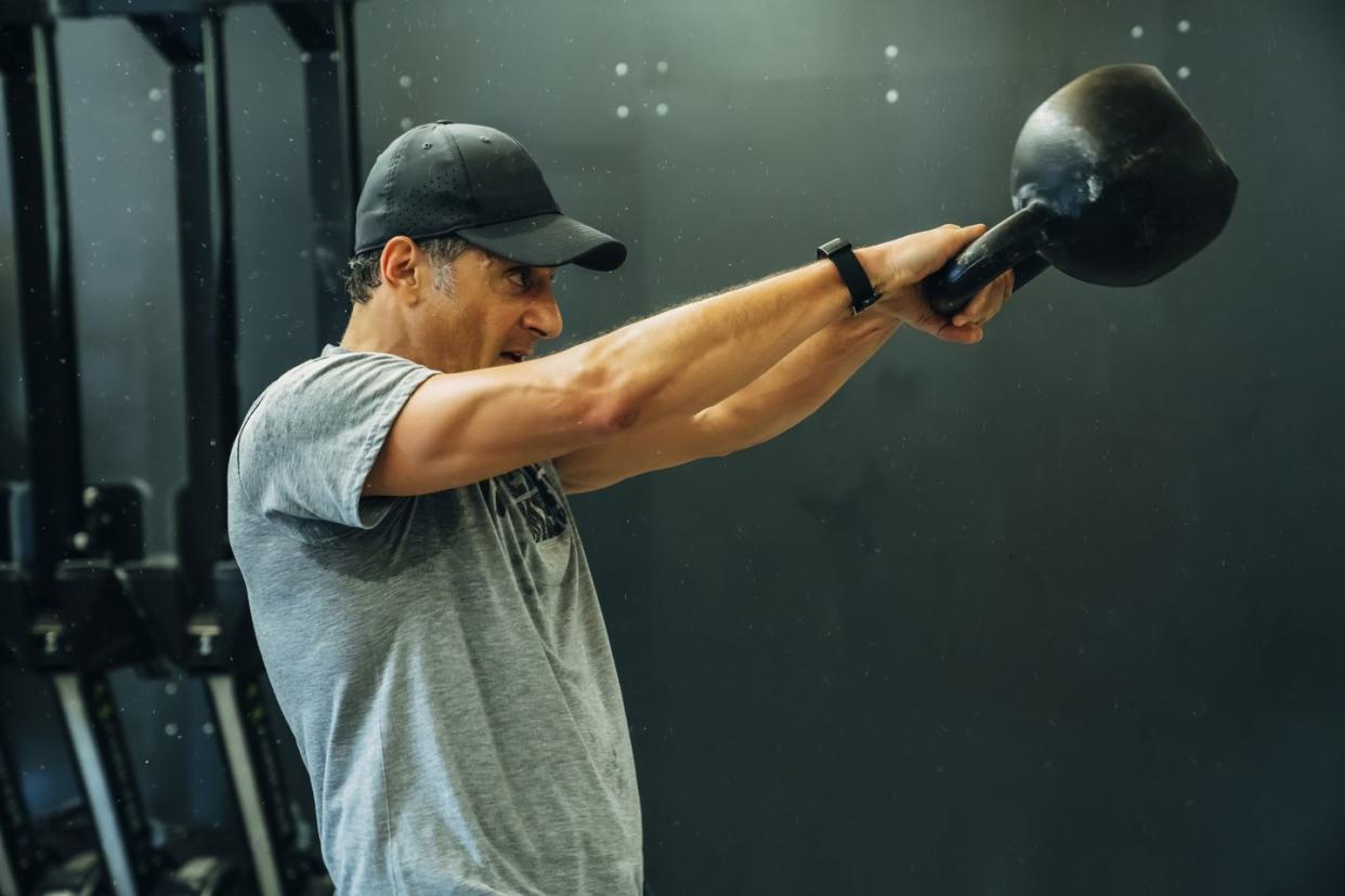 Portrait of Caucasian man lifting kettlebell