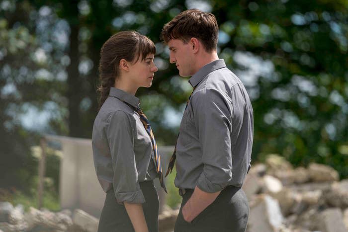 Daisy Edgar-Jones and Paul Mescal face each other, wearing collared shirts and ties in an outdoor setting