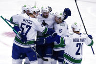 Vancouver Canucks center Jason Dickinson, center, celebrates with teammates after scoring against the Chicago Blackhawks during the first period of an NHL hockey game in Chicago, Thursday, Oct. 21, 2021. (AP Photo/Nam Y. Huh)