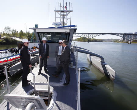 Visitors stand on the deck of the autonomous ship "Sea Hunter", developed by DARPA, docked in Portland, Oregon after its christening ceremony April 7, 2016. REUTERS/Steve Dipaola