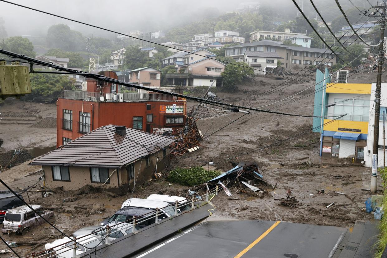 This photo shows buildings damaged by a mudslide at the Izusan district in Atami, west of Tokyo, Saturday, July 3, 2021, following heavy rains in the area. The mudslide carrying a deluge of black water and debris crashed into rows of houses in the town following heavy rains on Saturday, leaving multiple people missing, officials said. (Kyodo News via AP)