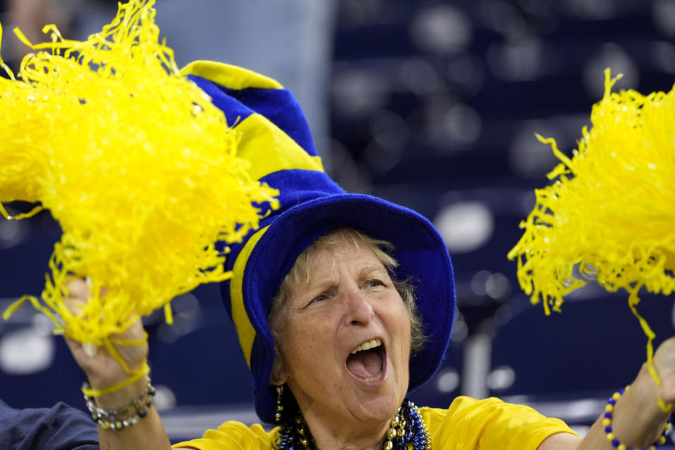 A Michigan fan cheers during warm ups before the national championship NCAA College Football Playoff game between Washington and Michigan Monday, Jan. 8, 2024, in Houston. (AP Photo/David J. Phillip)