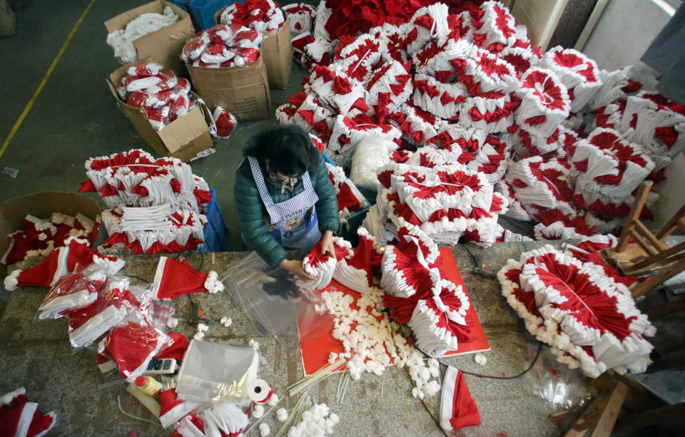 Eine Fabrikarbeiterin verpackt in Yiwu, Chinas "Weihnachtsstadt", NIkolausmützen. (Archivbild) - Copyright: picture alliance/Stringer/HPIC/dpa