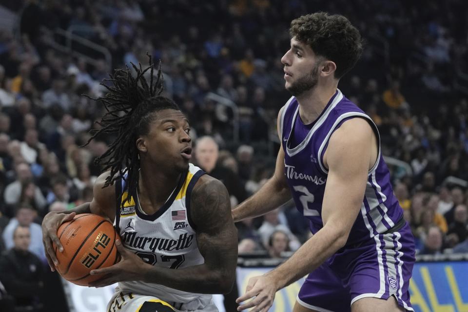 Marquette's Sean Jones tries to get past St. Thomas's Ben Nau during the first half of an NCAA college basketball game Thursday, Dec. 14, 2023, in Milwaukee. (AP Photo/Morry Gash)