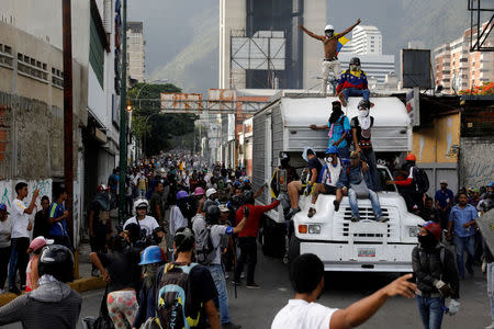 Demonstrators stand on a truck while clashing with riot security forces during a rally against Venezuela's President Nicolas Maduro in Caracas, Venezuela, May 31, 2017. REUTERS/Carlos Garcia Rawlins