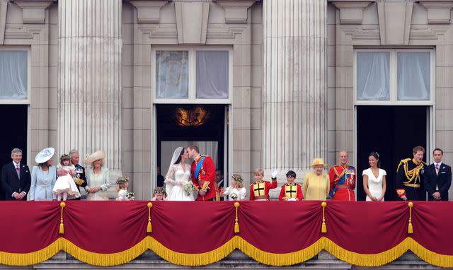 <p>LEON NEAL/AFP via Getty</p> Kate Middleton and Prince William kiss on the Buckingham Palace balcony on their April 2011 wedding day.