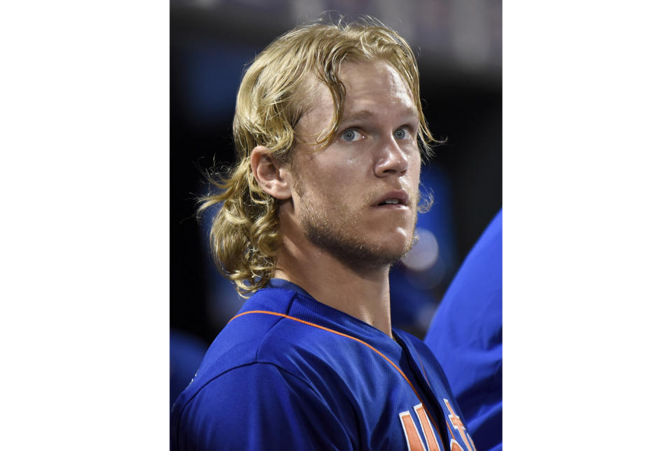 FILE - New York Mets pitcher Noah Syndergaard watches from the dugout after leaving the baseball game against the Arizona Diamondbacks on Friday, July 10, 2015, in New York. Syndergaard earned the moniker “Thor” for his flowing blonde locks. Astros starters Framber Valdez and Luis Garia look like naturals on the mound, but they've gotten an artificial boost from the barber shop. Both pitchers got hair extensions during this season. (AP Photo/Bill Kostroun, File)