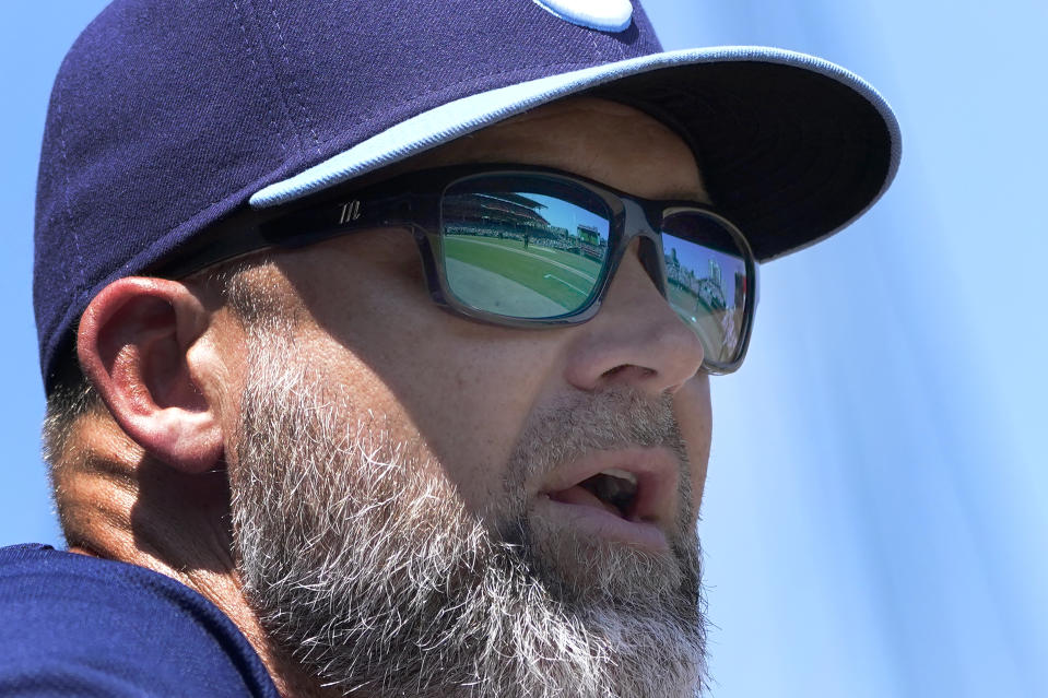 Wrigley Field is reflected in the sunglasses of Chicago Cubs manager David Ross during the first inning of a baseball game against the Miami Marlins Friday, Aug. 5, 2022, in Chicago. (AP Photo/Charles Rex Arbogast)