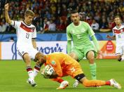 Algeria's goalkeeper Rais Mbolhi claims the ball infront of teammate Essaid Belkalem (2nd R) and Germany's Thomas Mueller (L) during their 2014 World Cup round of 16 game at the Beira Rio stadium in Porto Alegre June 30, 2014. REUTERS/Stefano Rellandini