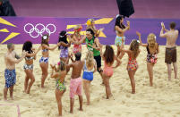 Germany's Jonathan Erdmann enters the court past dancers at the start of their men's preliminary round beach volleyball match against the Netherlands at the London 2012 Olympic Games at Horse Guards Parade July 31, 2012. (REUTERS/Lucy Nicholson)