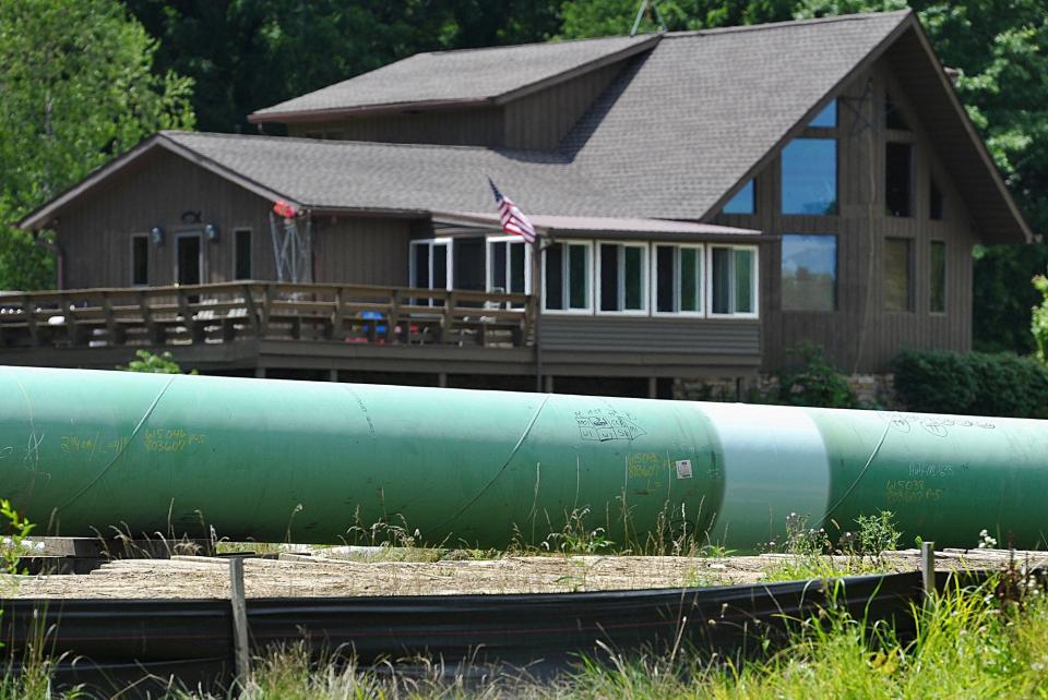 A section of the Nexus pipeline waits to be lowered into the ground in front of a Green home in July 2018.