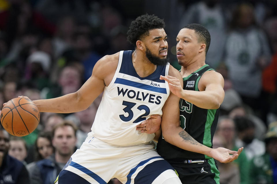 Minnesota Timberwolves center Karl-Anthony Towns (32) tries to drive to the basket past Boston Celtics forward Grant Williams, right, in the first half of an NBA basketball game, Sunday, March 27, 2022, in Boston. (AP Photo/Steven Senne)