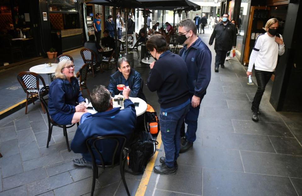 People enjoy a coffee together after measures to curb the spread of the Covid-19 coronavirus were eased allowing limited numbers of people back into shops, bars, cafes and restaurants in Melbourne.