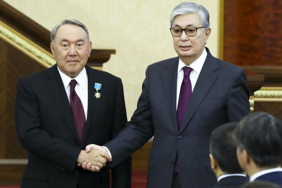FILE - Kazakhstan's interim president Kassym-Jomart Tokayev, right, and outgoing Kazakh President Nursultan Nazarbayev shake hands after an inauguration ceremony in Astana, Kazakhstan, Wednesday, March 20, 2019. Demonstrations broke out Jan. 2 in western Kazakhstan's oil-producing region over an increase in state-controlled gas prices as 2022 began. Those protests soon spread to the cities and morphed into broad criticisms of corruption, economic inequality and a continuing hold on politics and the country's energy wealth by its long-serving first leader, Nursultan Nazarbayev, and his family. Marchers referred to him by shouting "Old man out!" (AP Photo/File)