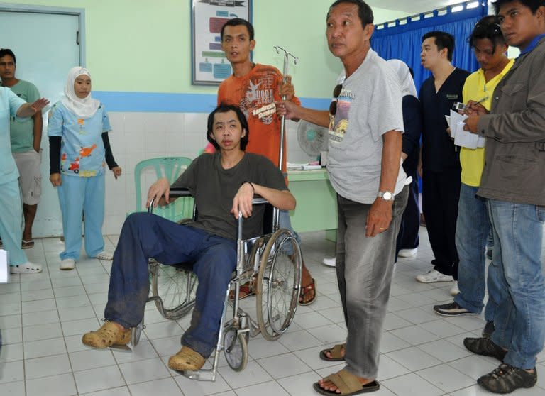 Tung Wei Jie (L), a Malaysian plantation worker held hostage by Philippine Muslim extremists for nine months, at a hospital in Jolo on August 6, 2013. He said he escaped before dawn under the cover of a tropical downpour after almost a year in abysmal conditions, reports said Sunday