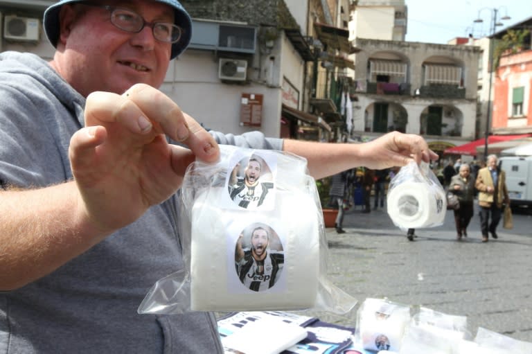 A vendor shows toilet paper rolls with portraits of Juventus' Argentinian forward Gonzalo Higuain on March 23, 2017 in a street of Naples