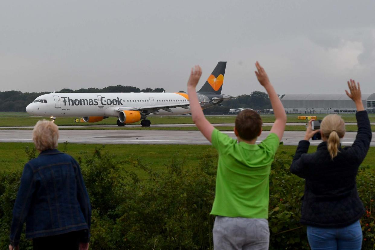 The pilot's family members wave as a Thomas Cook aircraft departs from Manchester Airport with the travel giant's future still uncertain: Getty