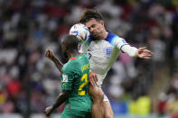 England's Jack Grealish jumps for the ball with Senegal's Youssouf Sabali, left, during the World Cup round of 16 soccer match between England and Senegal, at the Al Bayt Stadium in Al Khor, Qatar, Sunday, Dec. 4, 2022. (AP Photo/Manu Fernandez)