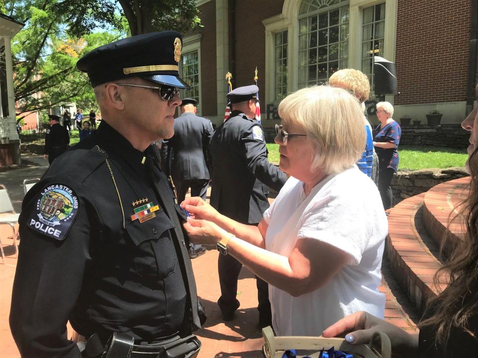 City police Lt. Matt Chambers receives an appreciation ribbon from Alisa Collins Tuesday at the city's annual memorial service for fallen law enforcement officers. Collins' son was Fairfield County Sheriff Dep. Ethan Collins, who was killed in the line of duty in 2006 in a motor vehicle crash.