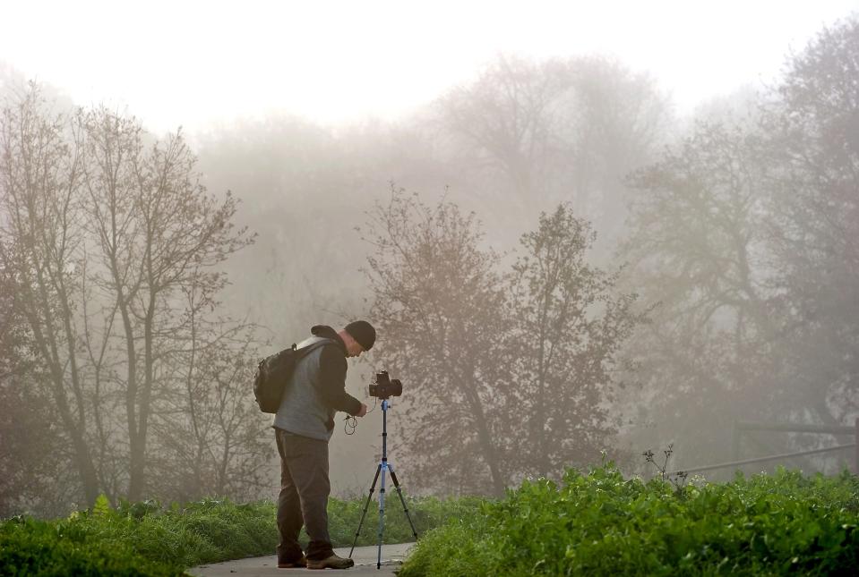 Ned Bagno of Concord braves the cold conditions to make some photographs on a foggy morning at the Cosumnes River Preserve near Thornton on Dec. 30, 2016.