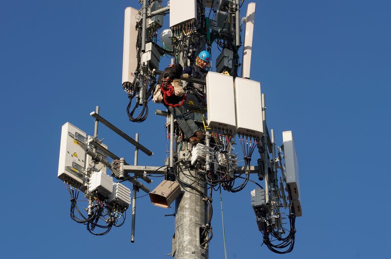 A crew from Verizon installs 5G equipment on a tower in Orem