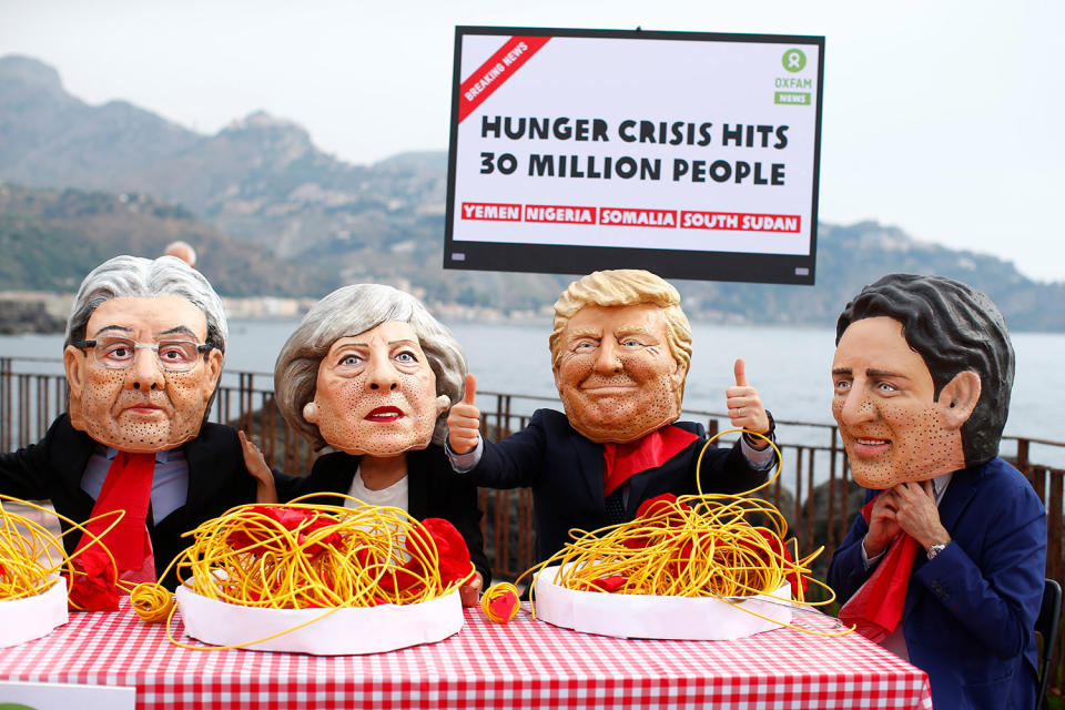 Protesters wear masks depicting the leaders of the G7 countries in Italy